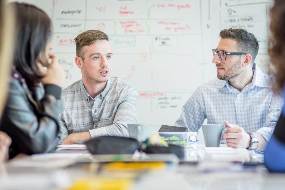 Early-stage founders working through ideas around a whiteboard